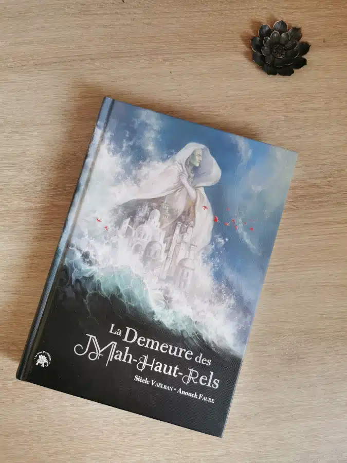 La couverture du roman La demeure des Mah-Haut-Rels, de Siècle Vaëlban, où la silhouette d'un homme se détache sur une cité blanche entourée de vagues.
