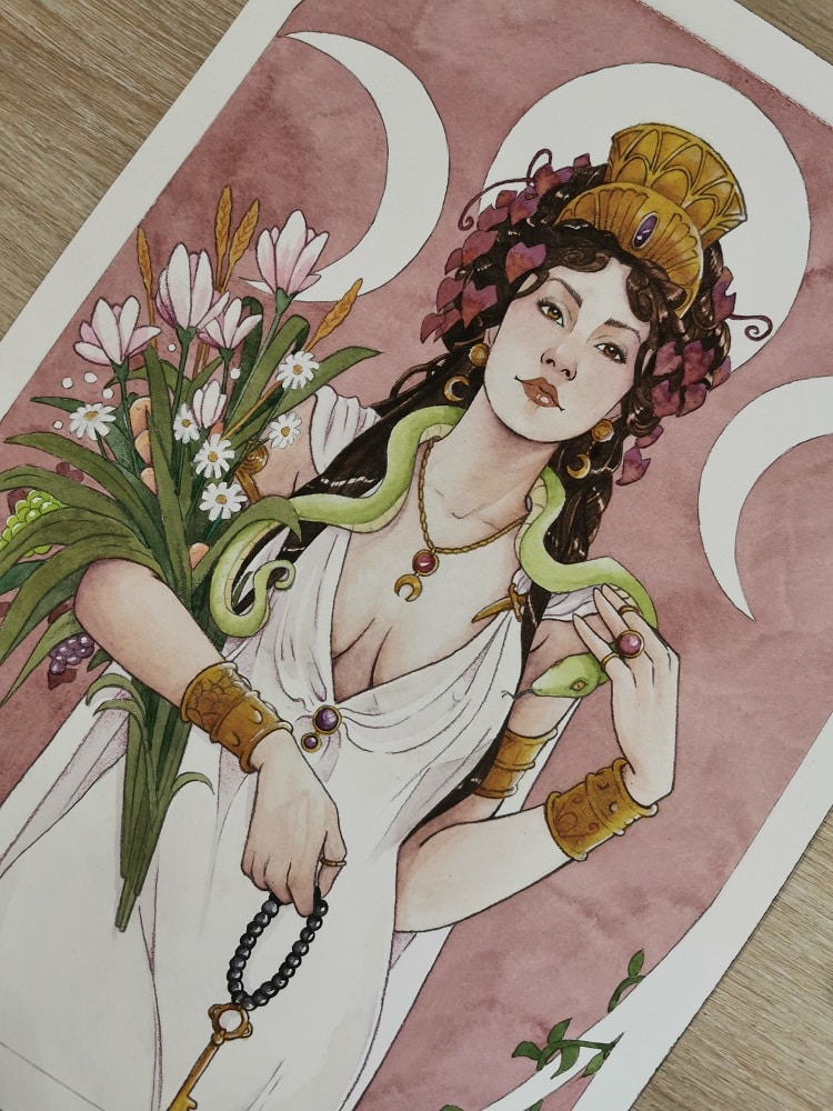 Une aquarelle représentant la déesse Hécate debout dans une longue robe blanche, avec un bouquet de fleurs dans les bras et un serpent vert lové autour de son cou. Elle porte une couronne d'or sur la tête et de la vigne rouge dans les cheveux.