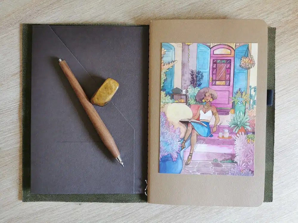 La couverture du carnet que j'utilise comme bullet journal, un cahier Moleskine sur lequel j'ai collé une carte postale de La maison de la sorcière, une de mes aquarelles.