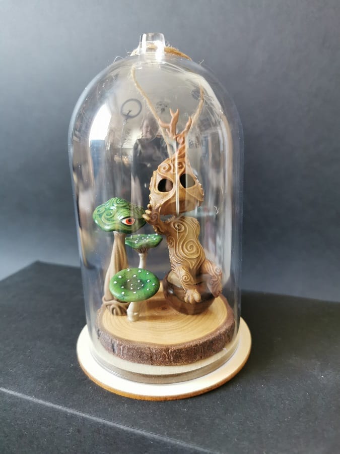 Un kodama en pleine séance de méditation sous une cloche transparente.