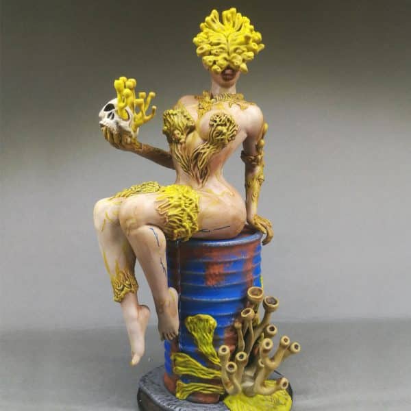 Une pinup infectée par le cordyceps, assise sur un bidon rouillé.