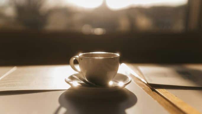 Une tasse à café posée au soleil, en contre-jour.