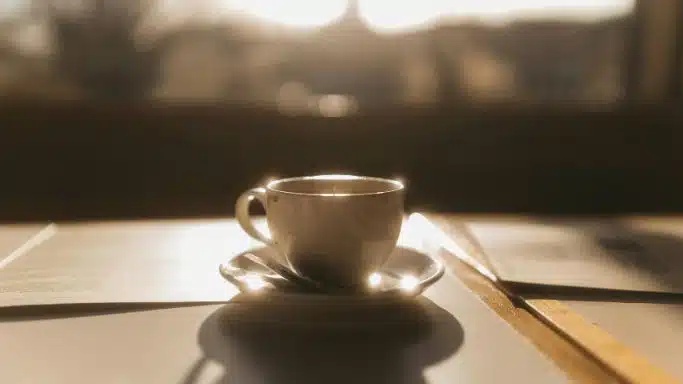 Une tasse à café posée au soleil, en contre-jour.