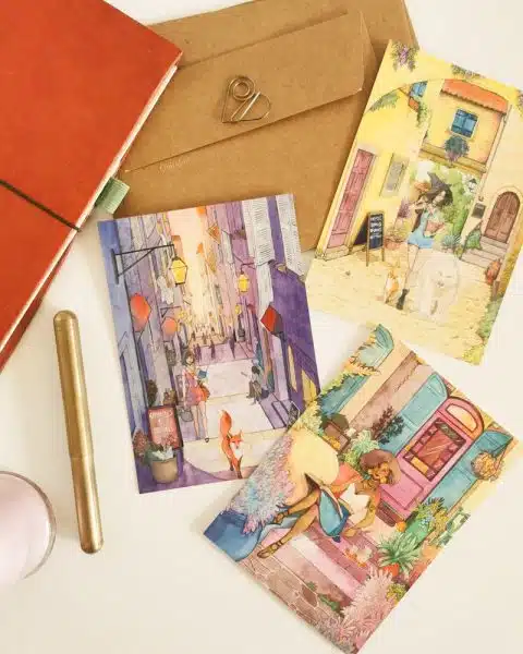 3 cartes postales très colorées représnetant de joyeuses sorcières dans un cadre urbain.