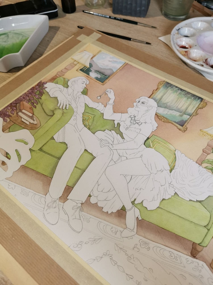 Une aquarelle en cours de peinture sur mon bureau, avec le décor peint dans des tons chauds, et les personnages encore en blancs.
